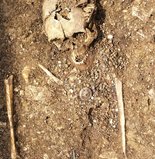 Ausgrabung mit Skelett und Funden